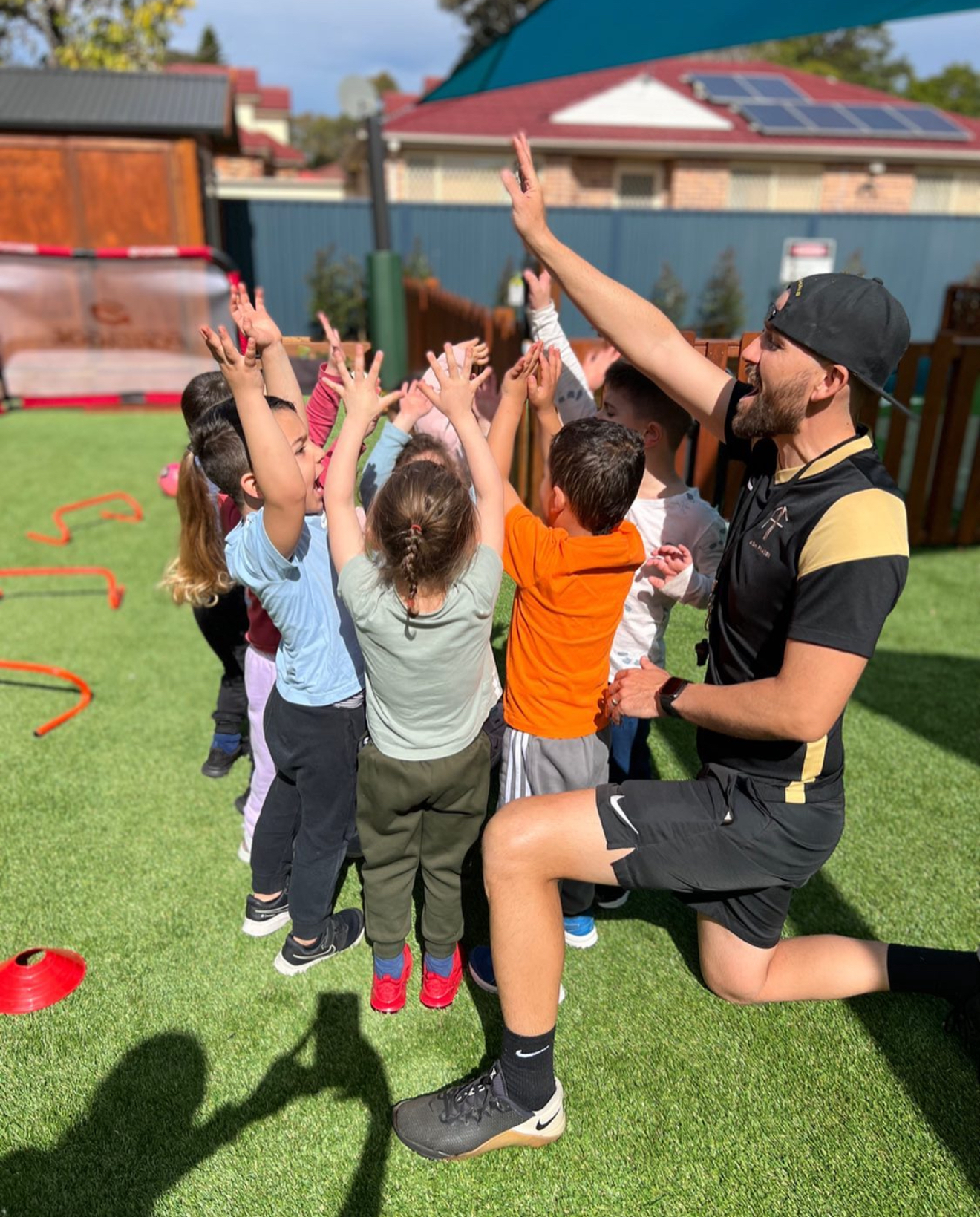 Kids celebrating their teamwork with high-fives after a team huddle.